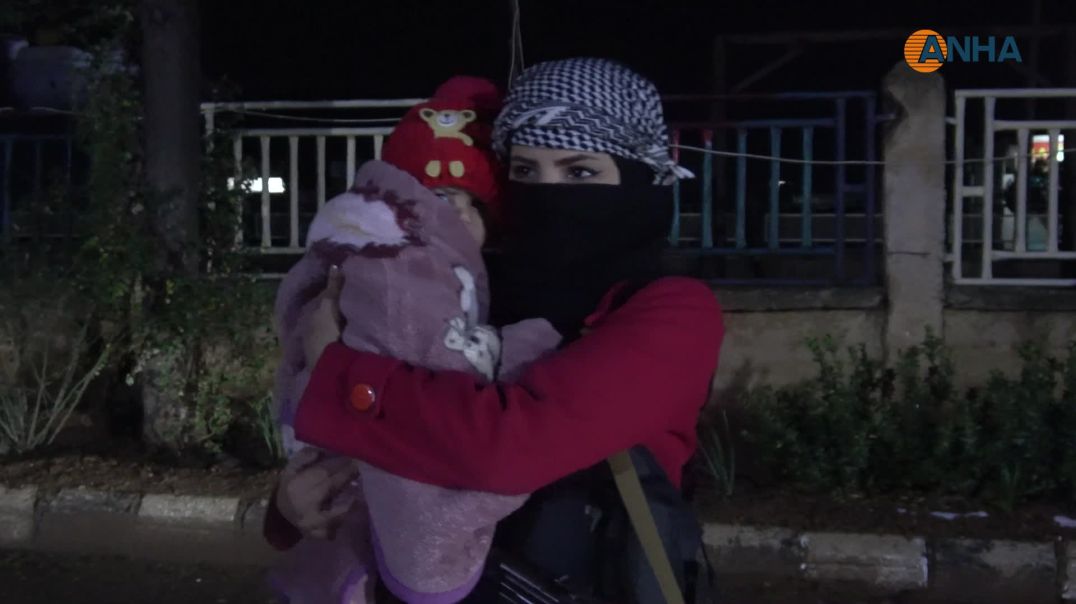 امرأة تحمل طفلتها وتشارك في حماية المنطقة ضمن النفير العام